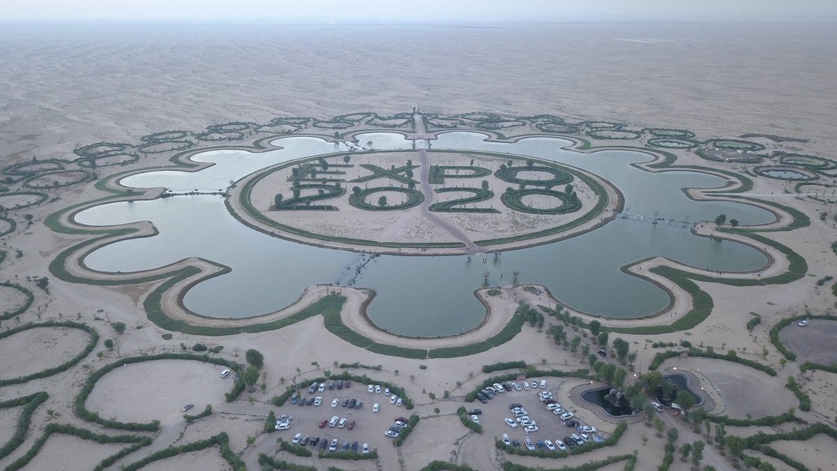 The ornamental lake and flower-shaped grounds of the Expo site in Dubai South from the air, desert beyond
