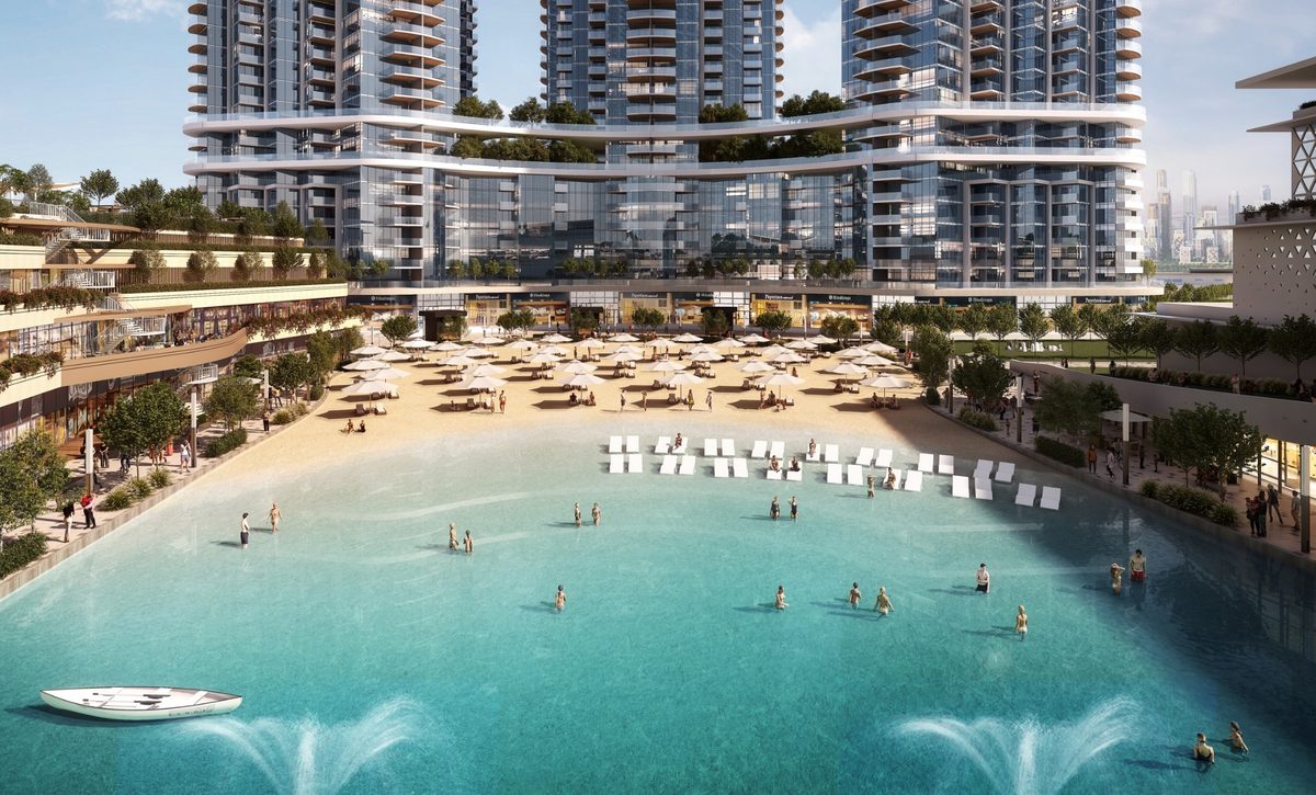 The lagoon beach cove at Sobha Hartland II: swimmers, loungers, a boat, the towers behind