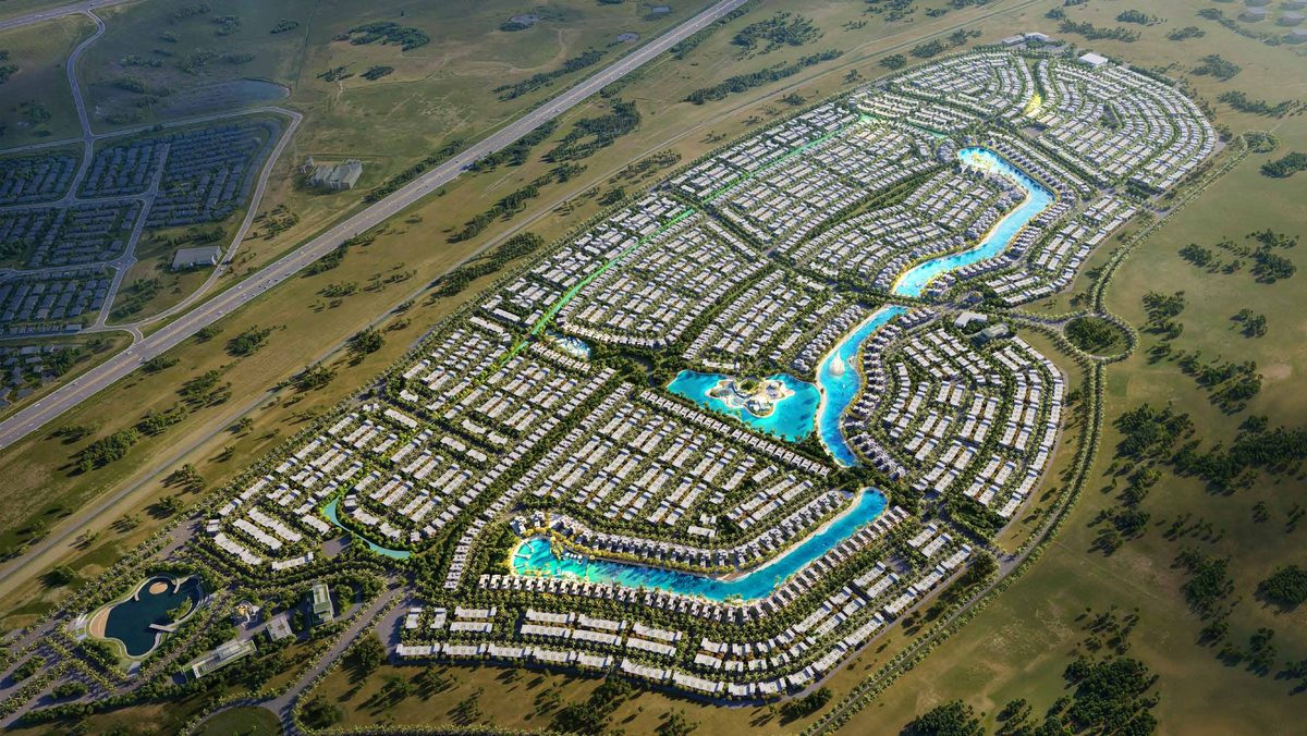 DAMAC Islands from above: the lagoon river threading the townhouse grid, desert on the horizon, from the developer's brochure