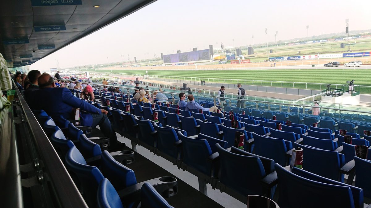 The Meydan racecourse grandstand on race day, the Dubai skyline behind