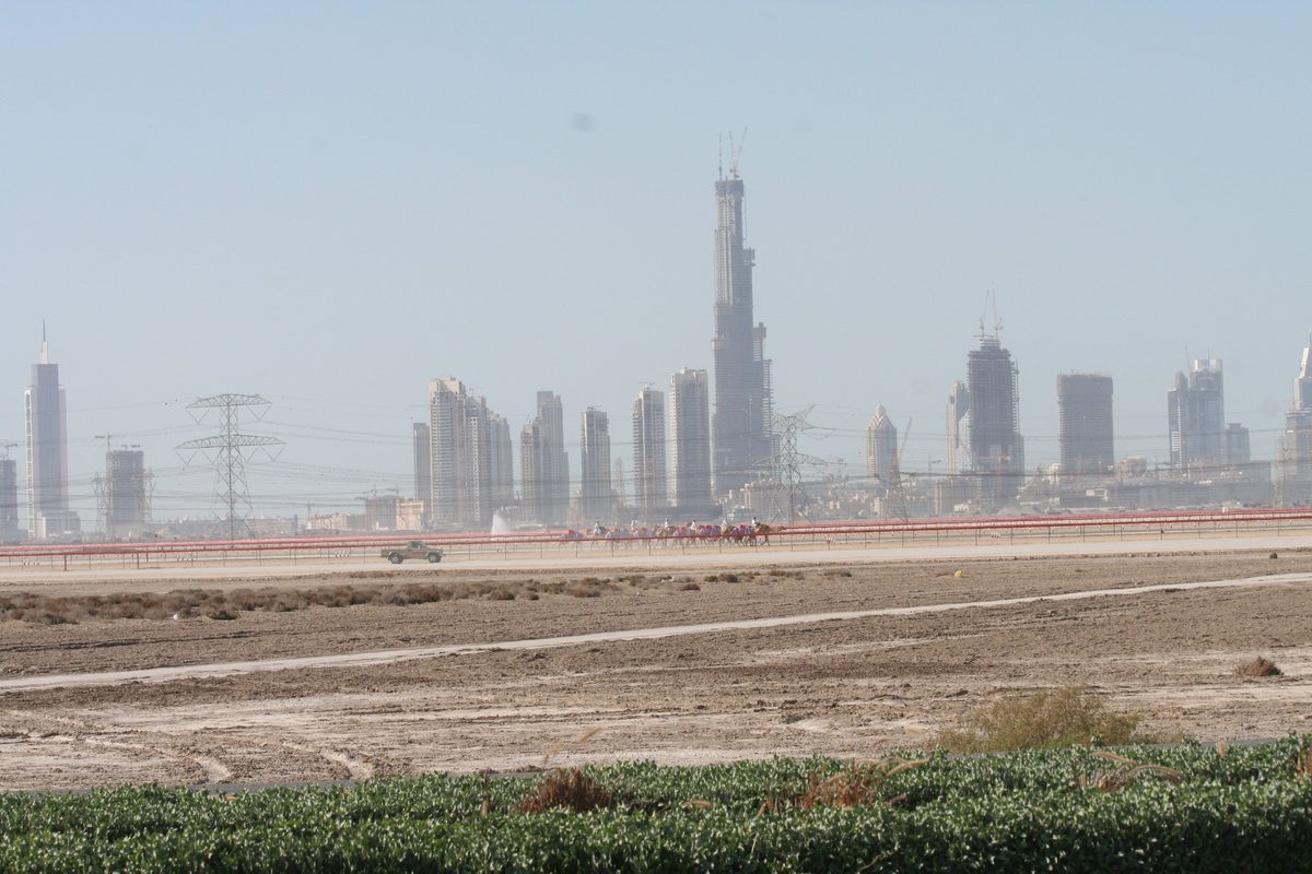 The Nad Al Sheba camel track in the desert with the Downtown Dubai skyline on the horizon