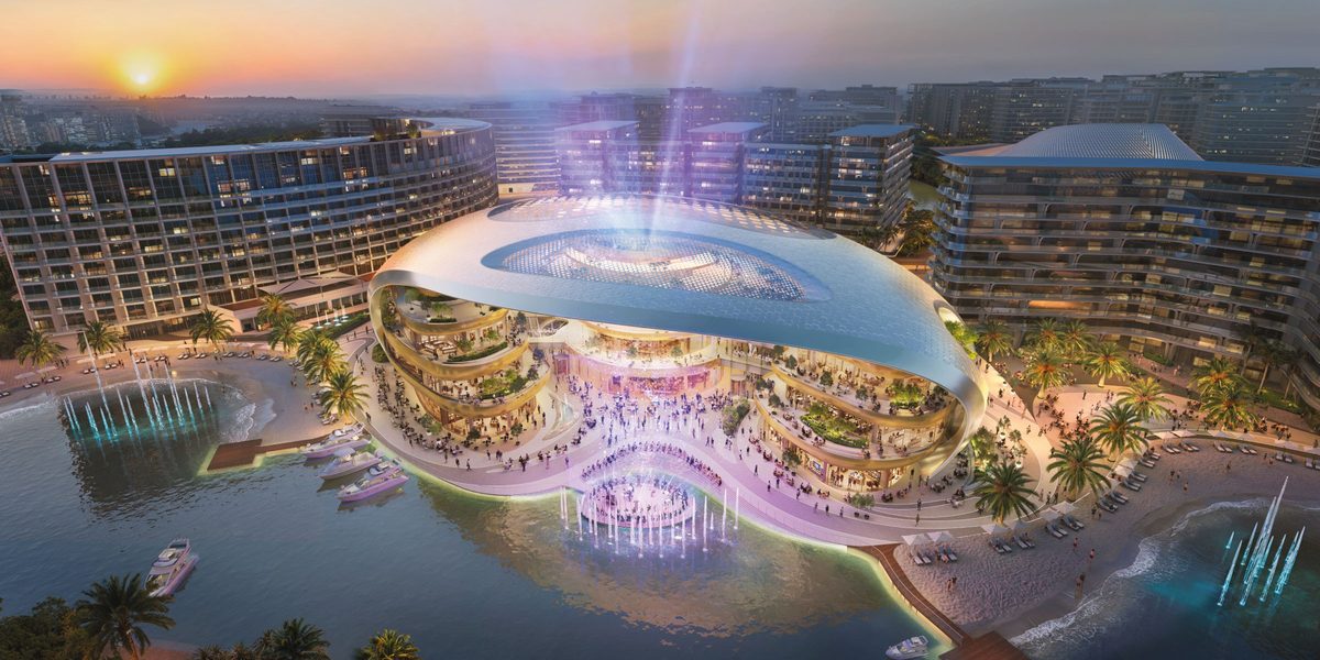 Azizi Venice at dusk from the air: the opera house on its island in the lagoon, fountains, apartment blocks behind