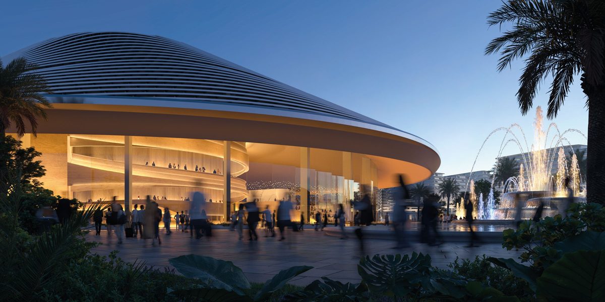 The opera house at Azizi Venice at dusk: a curved ribbed roof, a crowd on the plaza, water jets